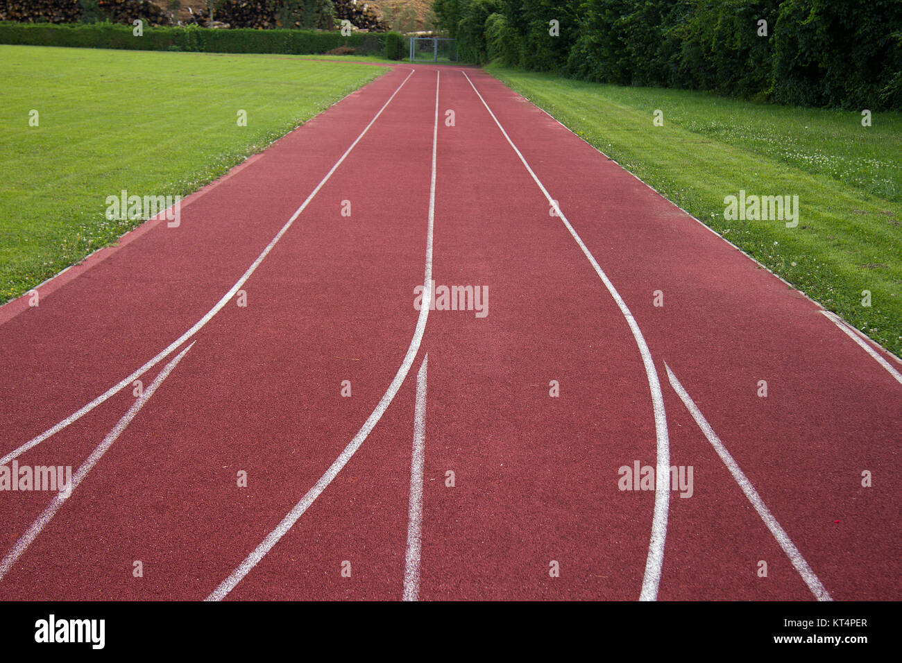 sports field with red running track and white stripes in styria in summer Stock Photo
