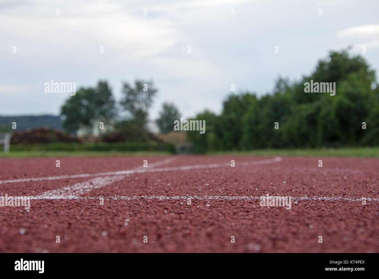 sports field with red running track and white stripes in styria in summer Stock Photo