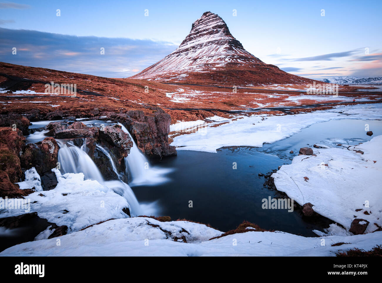 Iceland's iconic Kirkjufell and Kirkjufellsfoss during the blue hour Stock Photo