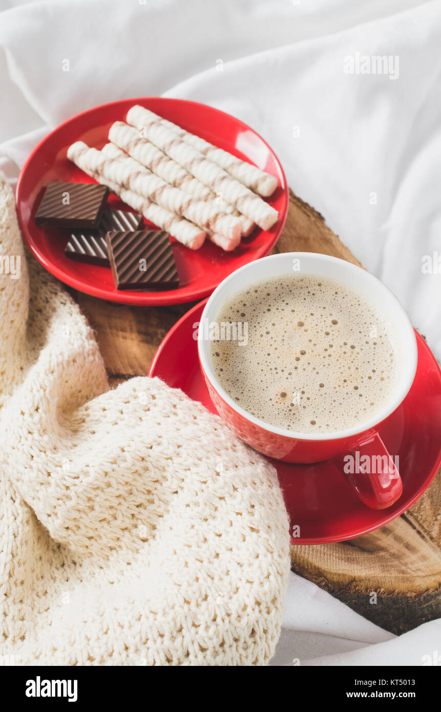 Cappuccino and Chocolate on a Bed with Plaid. Stock Photo