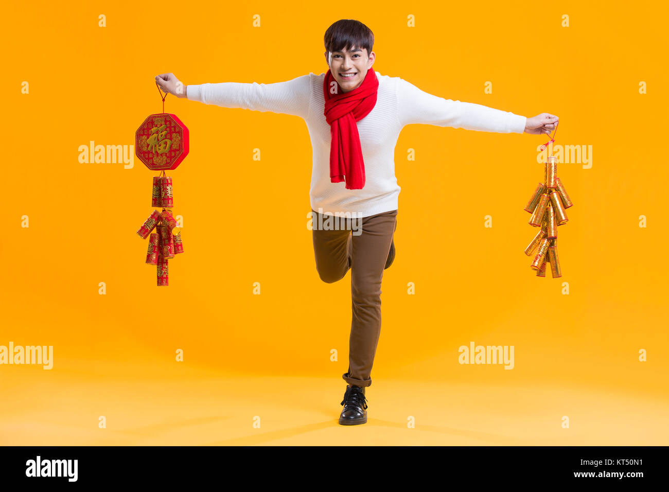 Cheerful young man celebrating Chinese new year with petards Stock Photo