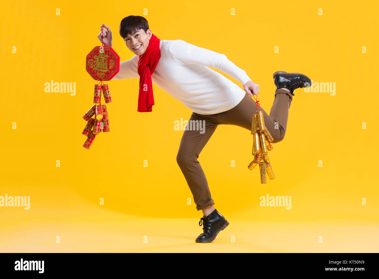 Cheerful young man celebrating Chinese new year with petards Stock Photo