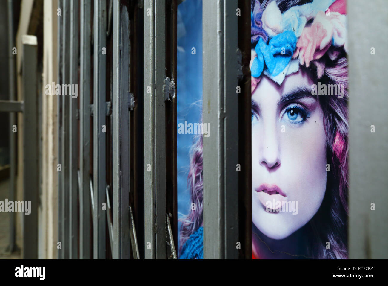 Advertising poster with face of beautiful female model behind security railings on beauty parlour entrance, La Paz, Bolivia Stock Photo