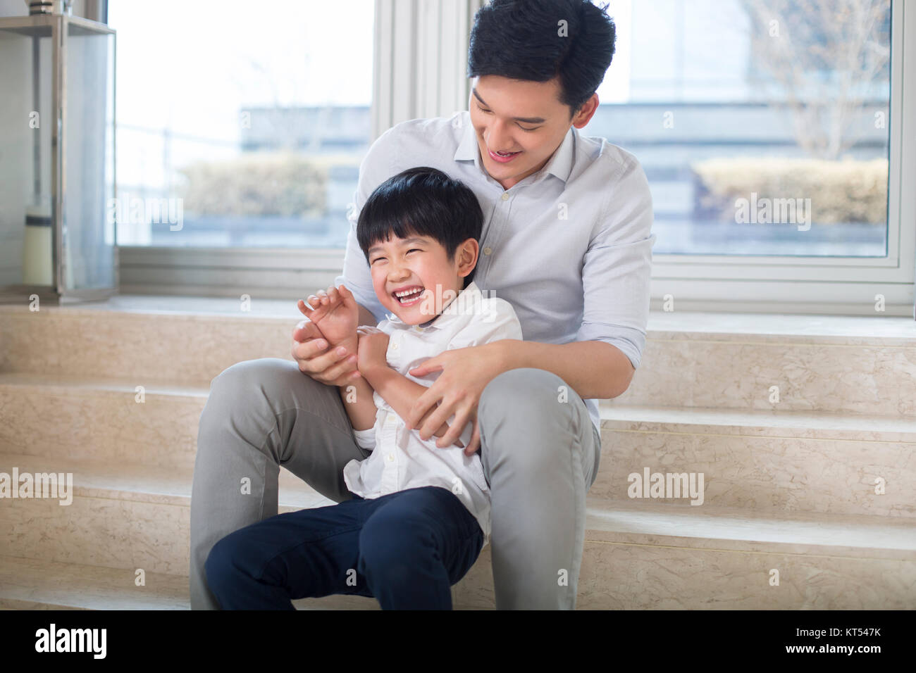 Cheerful father and son playing in the living room Stock Photo