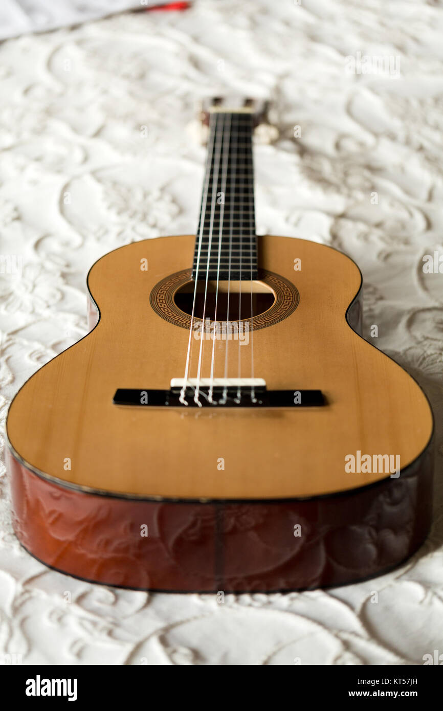 Spanish guitar lying on the bed Stock Photo Alamy