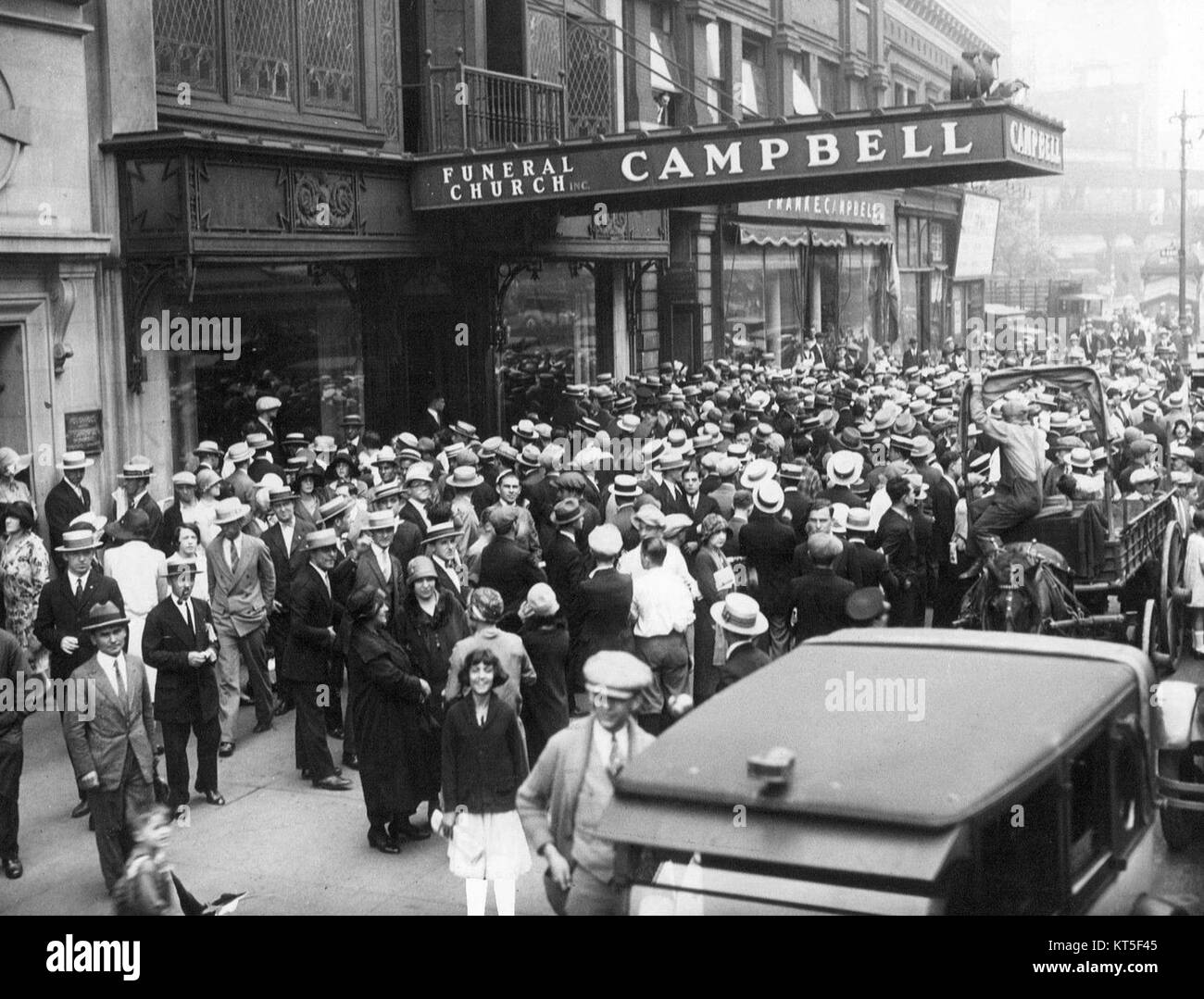 This image captures a scene from the funeral of Rudolph Valentino in 1926, a major event in Hollywood history. Valentino was a famed silent film actor known for his roles in films like 'The Sheik.' His death, at the age of 31, caused widespread mourning and led to significant public attention, reflecting his status as a beloved cinematic icon. Stock Photo