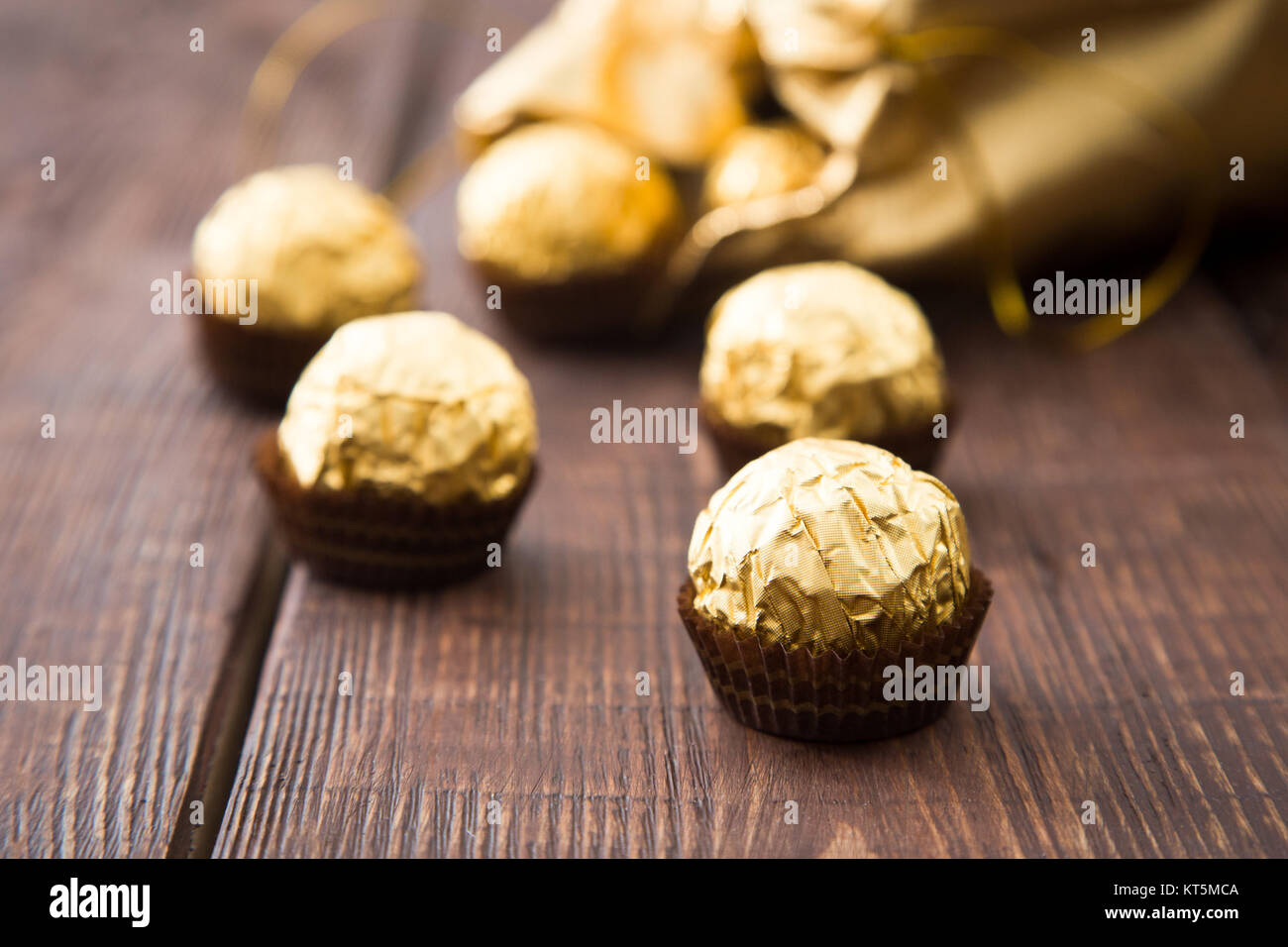 gold bag of chocolates. candy in Golden foil with copy space Stock