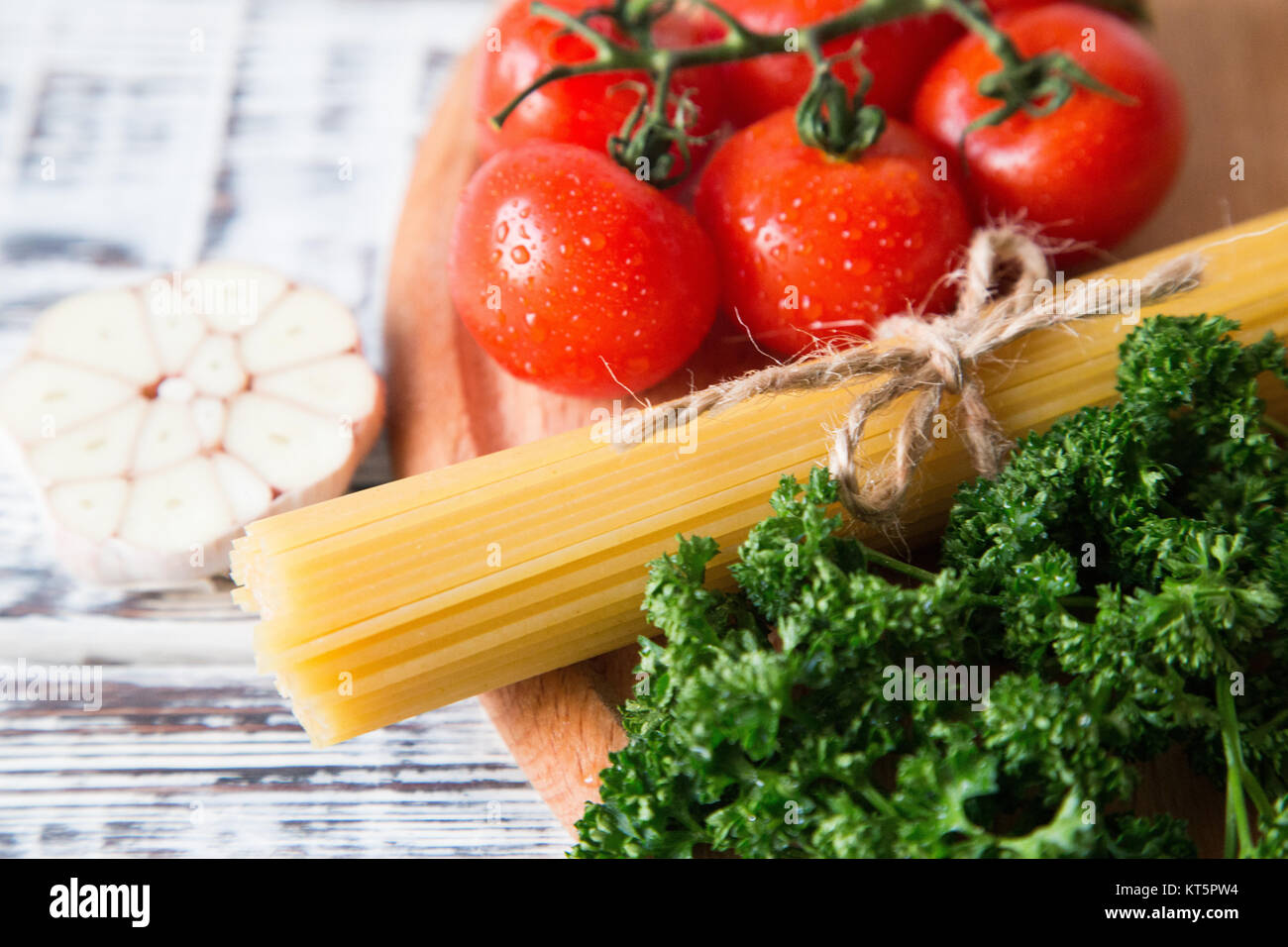 Spaghetti and tomatoes with herbs on an old wooden table Stock Photo ...