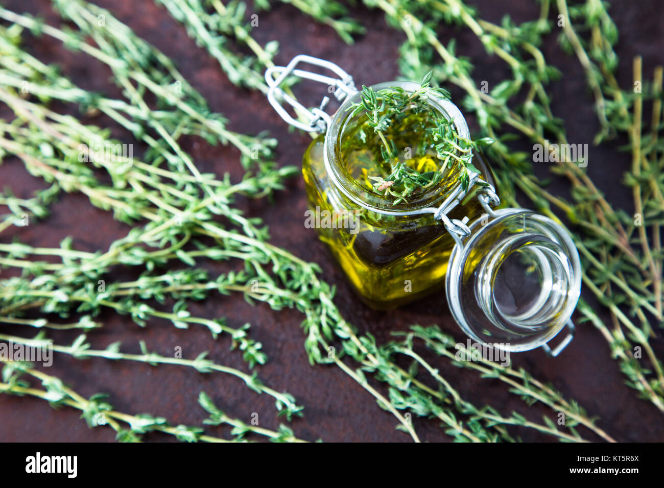 Thyme oil. Thyme essential oil jar glass bottle and branches of plant