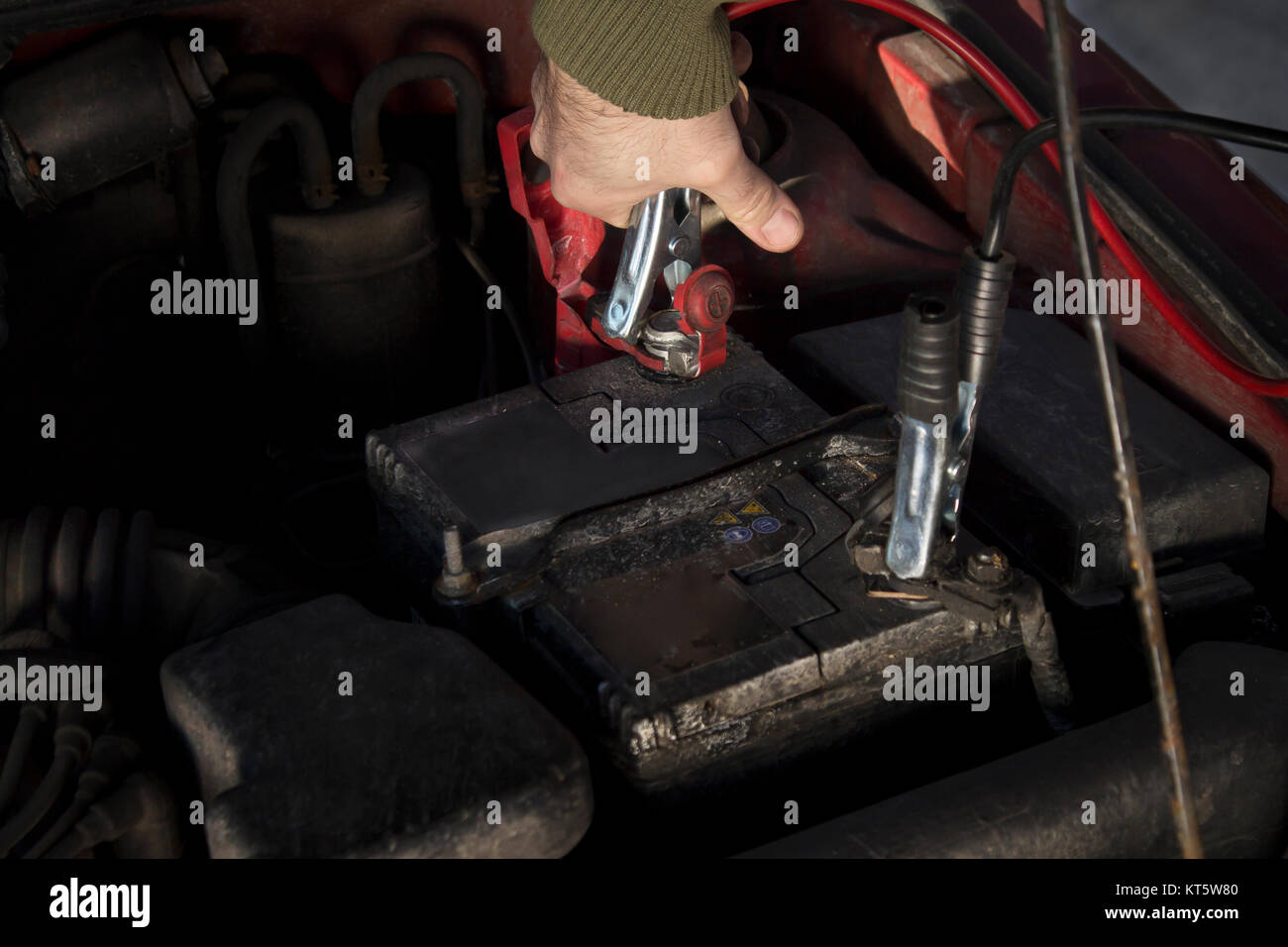 mechanic jumper cables connected to a discharged battery. Stock Photo