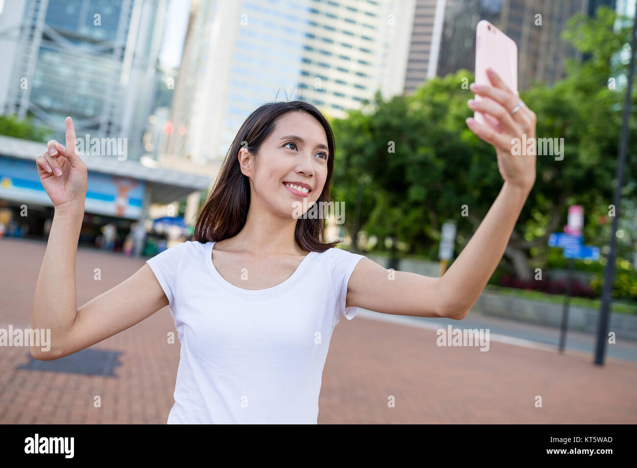 Woman taking photo by mobile phone in Hong Kong city Stock Photo - Alamy
