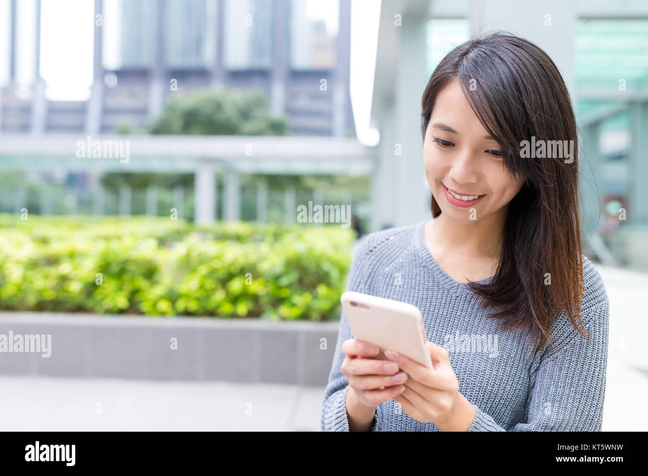 Woman using cellphone in Hong Kong Stock Photo - Alamy