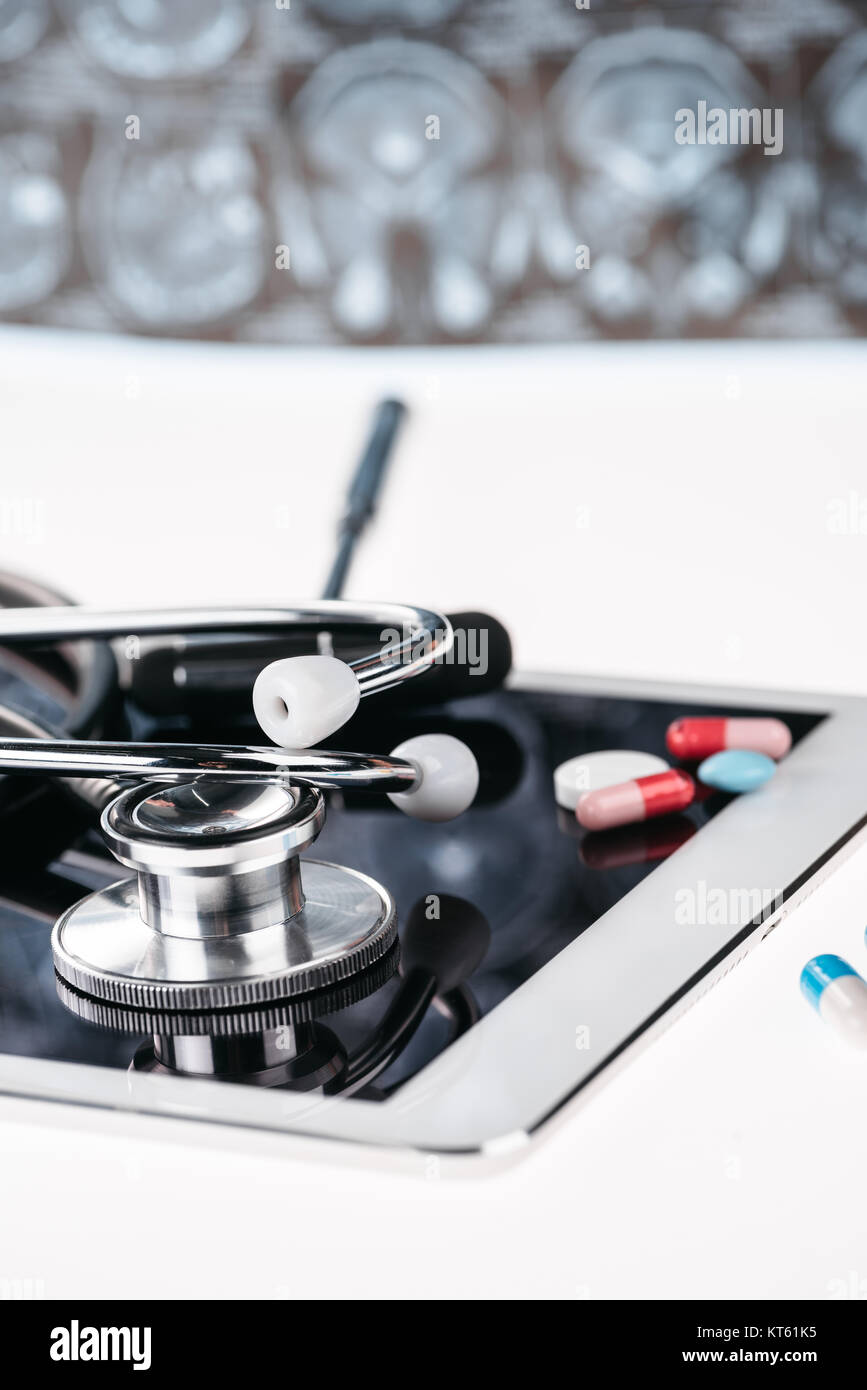 close up view of stethoscope on digital tablet and pills on white Stock ...