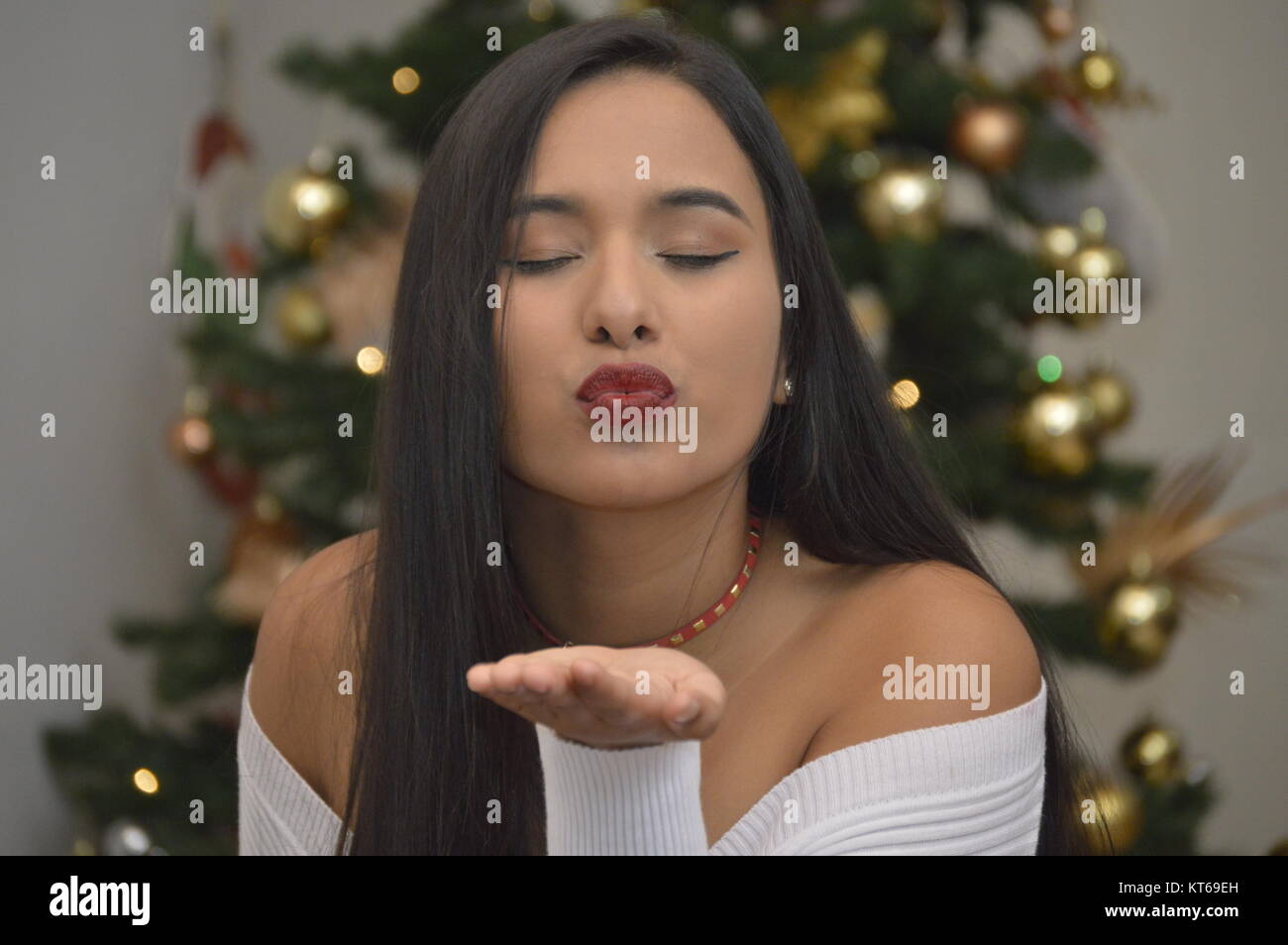 Hispanic girl kissing you. Venezuelan Christmas scene Stock Photo