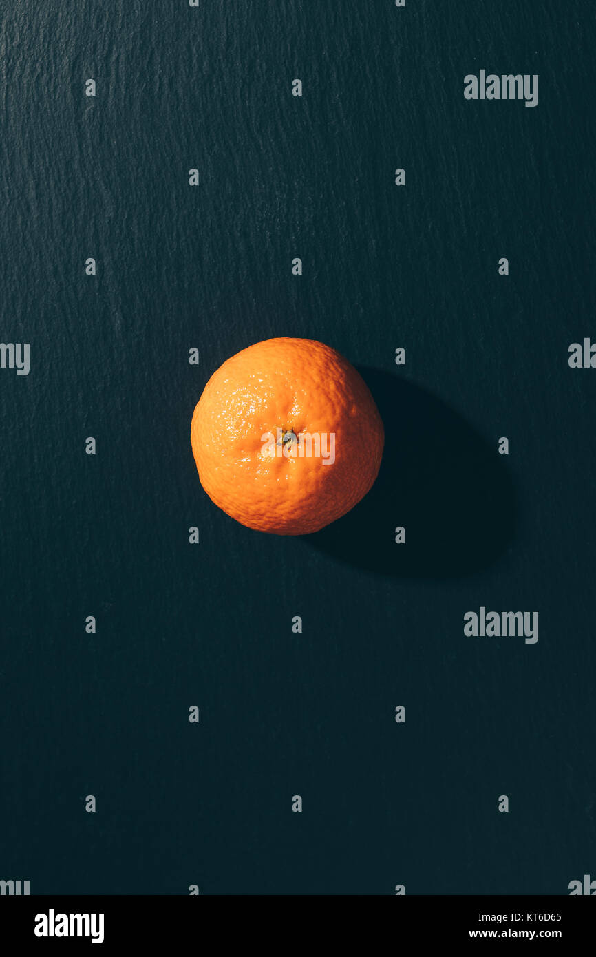 Mandarin on a black table top view vertical cropping Stock Photo