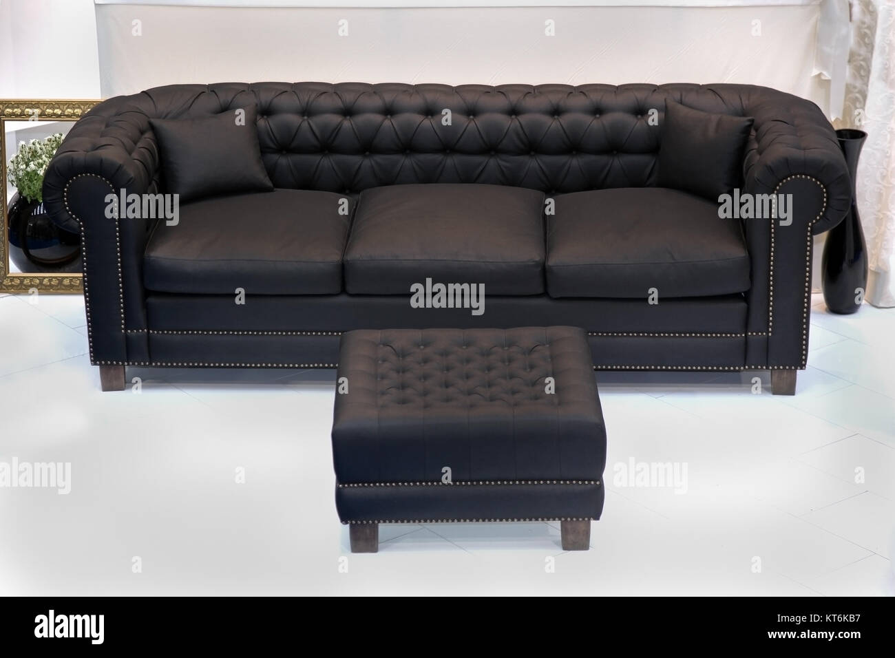 Black leather vintage sofa with leg rest ottoman Stock Photo - Alamy