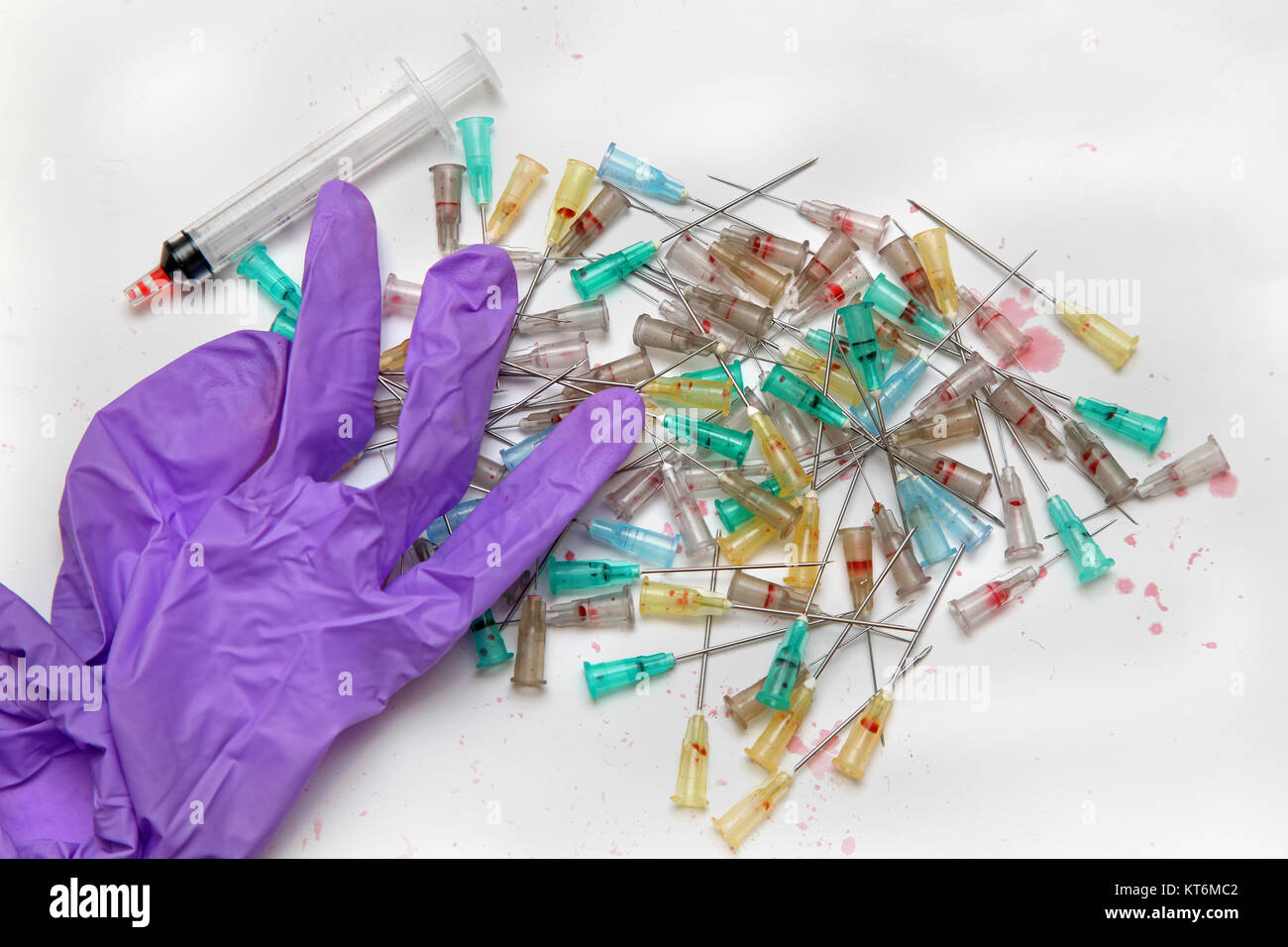 Bunch of used needles for medical waste with syringe and surgical glove