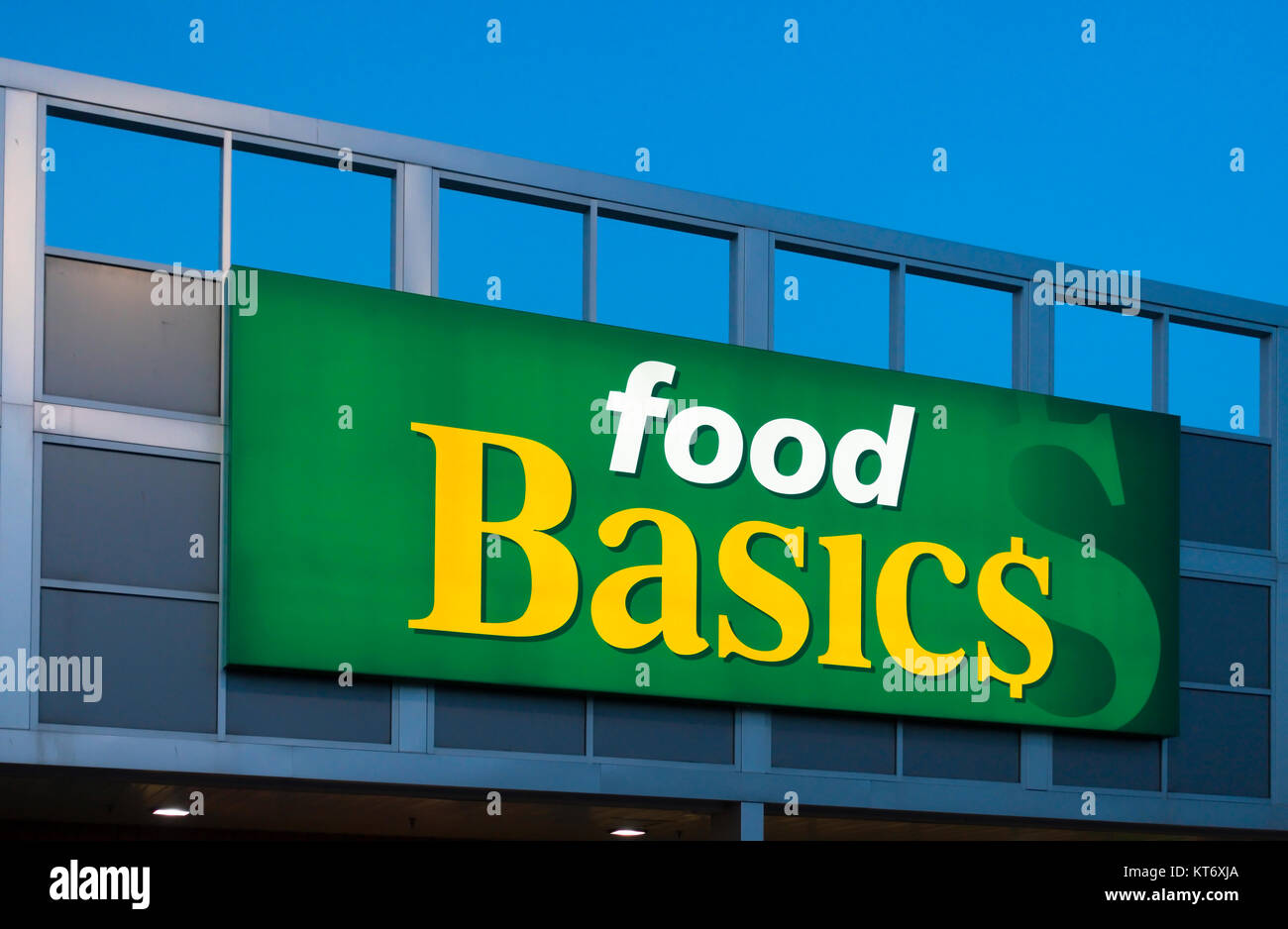 A Food Basics sign illuminated at dusk.  Food Basics is owned by Metro Incorporated and is a supermarket chain store in Canada. Stock Photo