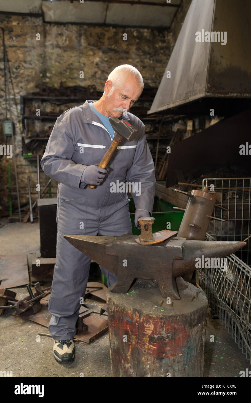 senior male blacksmith using hammer over anvil Stock Photo - Alamy