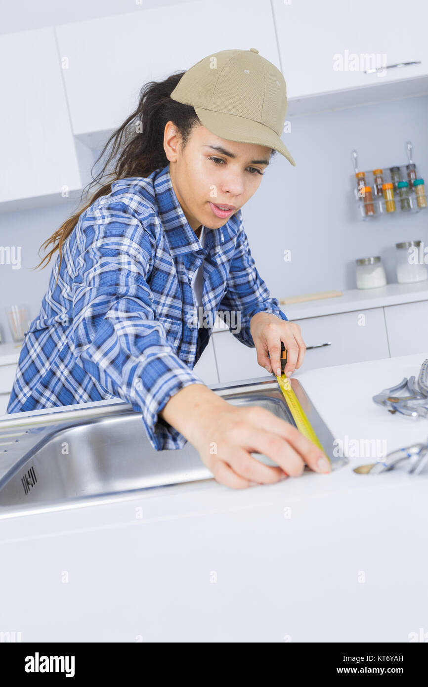Lady measuring kitchen sink Stock Photo Alamy