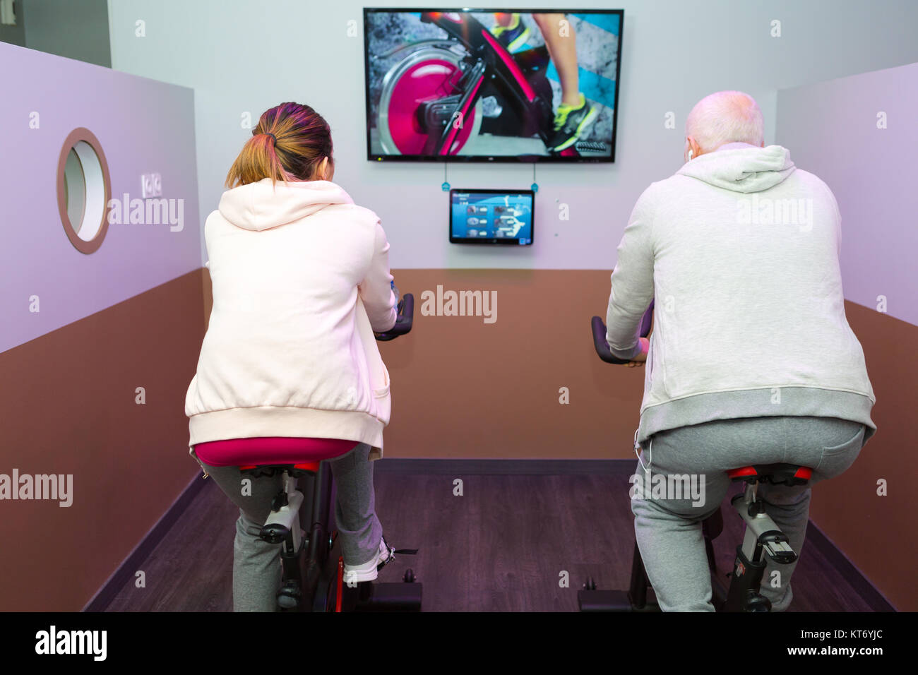 senior man and woman spinning on fitness bikes Stock Photo