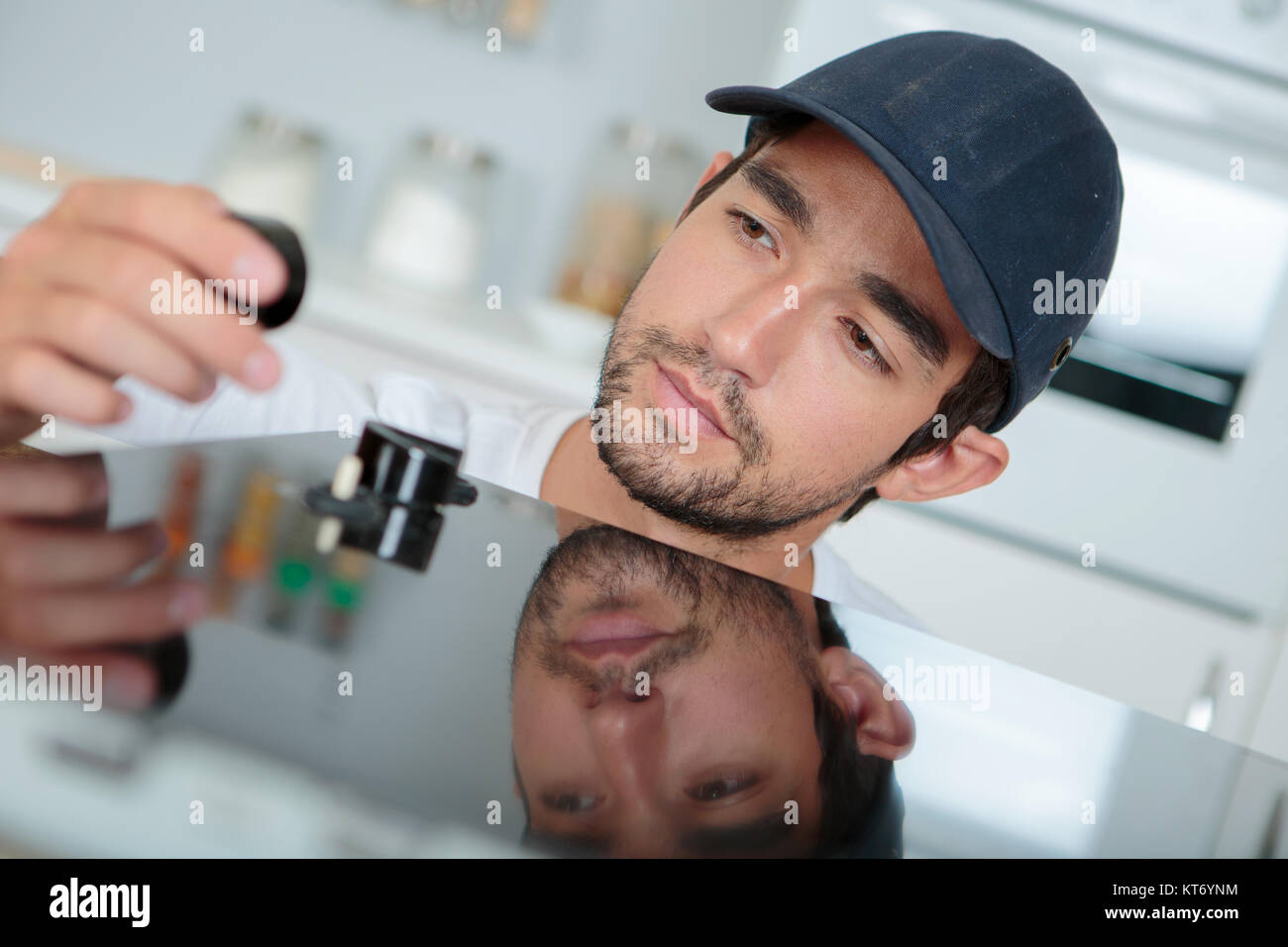 Young man installing kitchen hob Stock Photo Alamy
