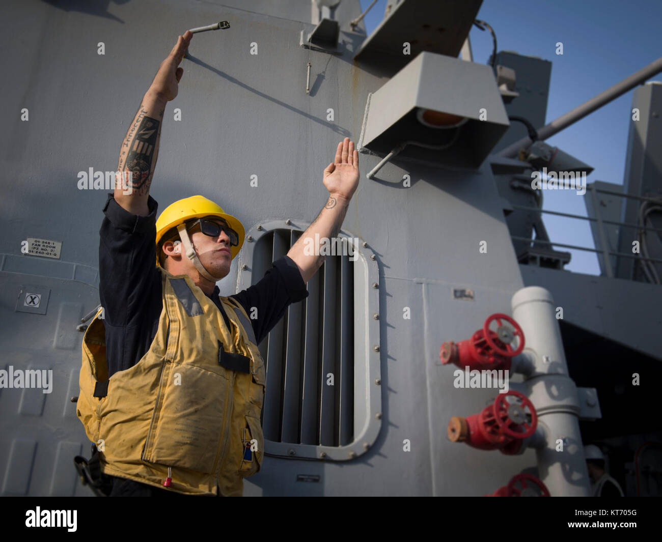 Boatswain’s Mate 2nd Class Matthew C. Robertson signals to the USNS Alan Shepard (T-AKE 3) during a replenishment-at-sea aboard the Arleigh Burke-class guided-missile destroyer USS Preble (DDG 88). Preble is deployed with the Theodore Roosevelt Carrier Strike Group to the U.S. 5th Fleet area of operations in support of maritime security operations to reassure allies and partners and preserve the freedom of navigation and the free flow of commerce in the region. (U.S. Navy Stock Photo