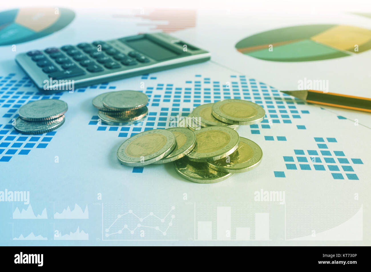 Coin stacks, calculator and pencil on paper of financial graph. Business concept. Stock Photo