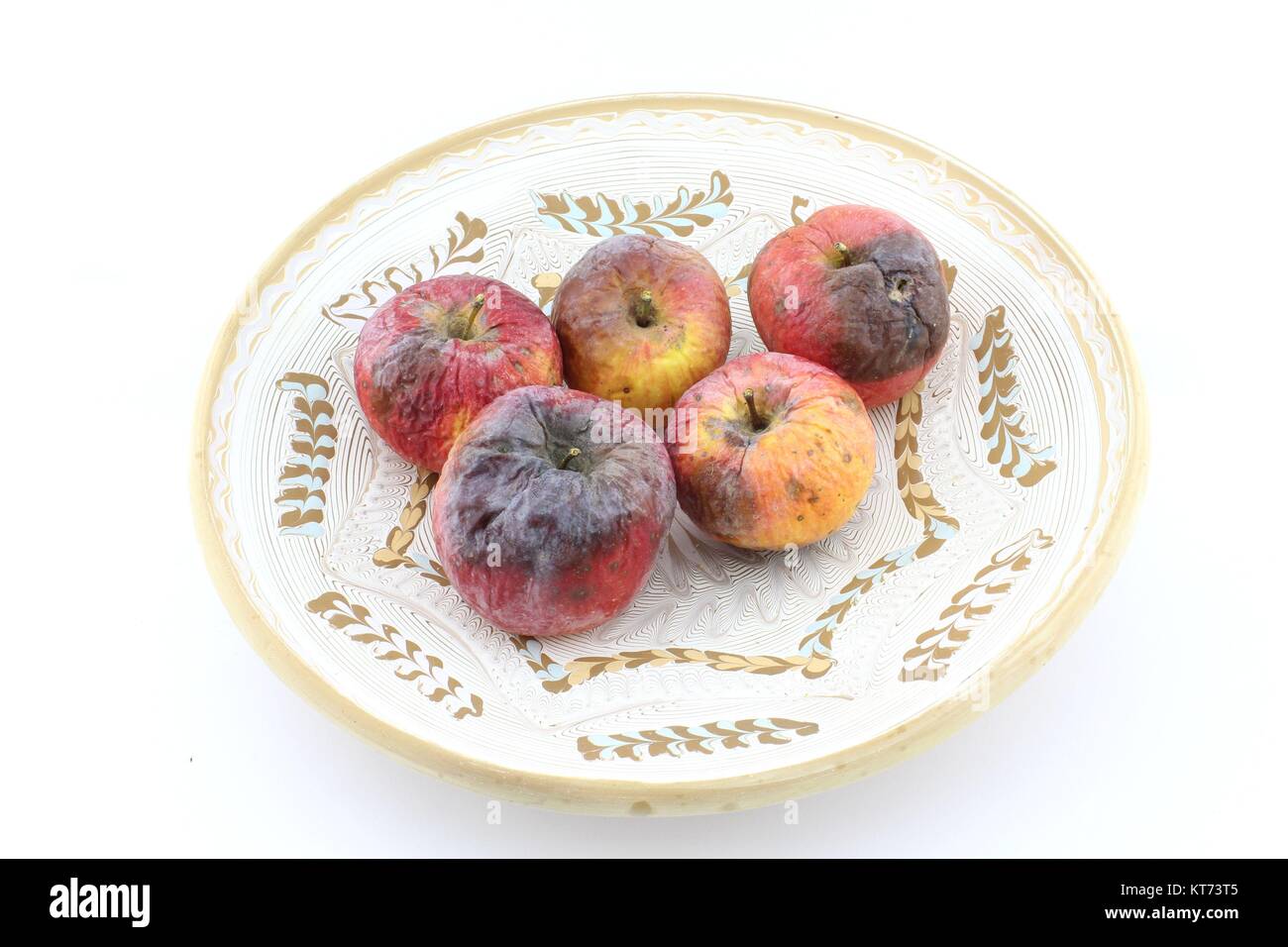 Rotten apple on decorative plate Stock Photo
