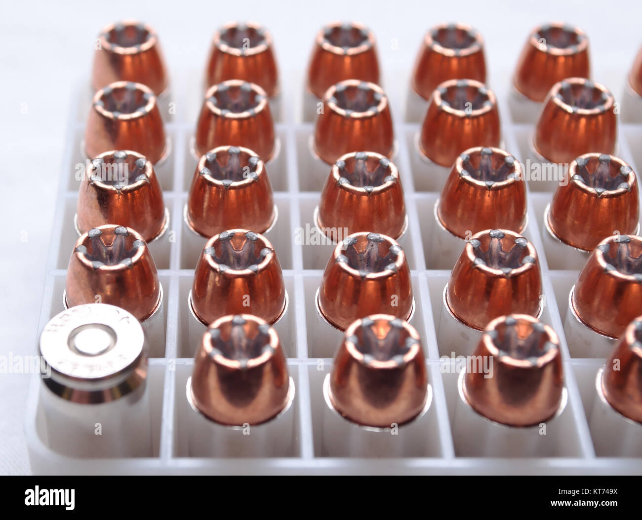 An ammo box containing .40 caliber hollow point bullets with one reversed showing the primer Stock Photo