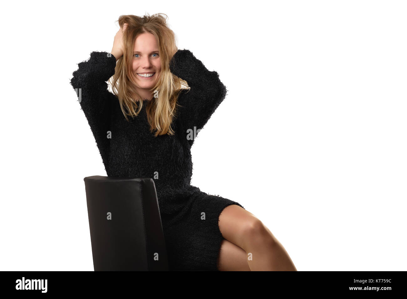 smiling blonde woman in fluffy black dress tearing her hair Stock Photo