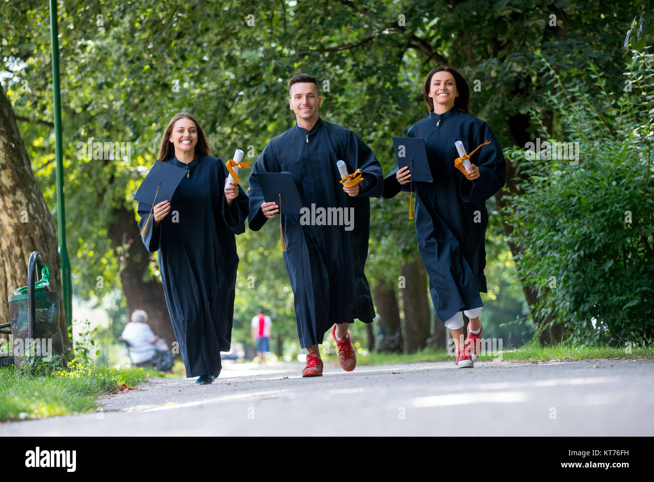 education, graduation, people concept - group of happy international students in mortar boards and bachelor gowns with diplomas Stock Photo