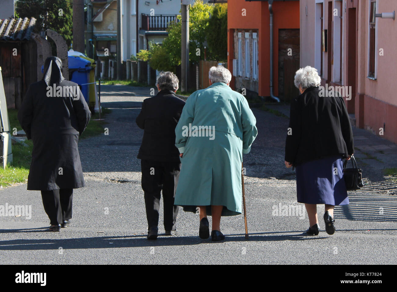 four old ladies walking down the street together Stock Photo