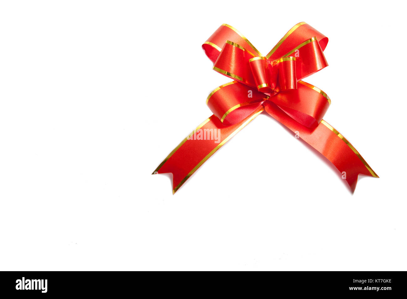 Corner with small red silk ribbon bow isolated on white Stock
