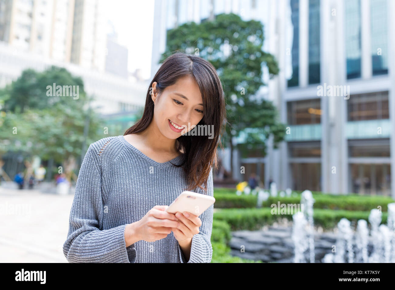 Woman working on cellphone at Hong Kong city Stock Photo - Alamy