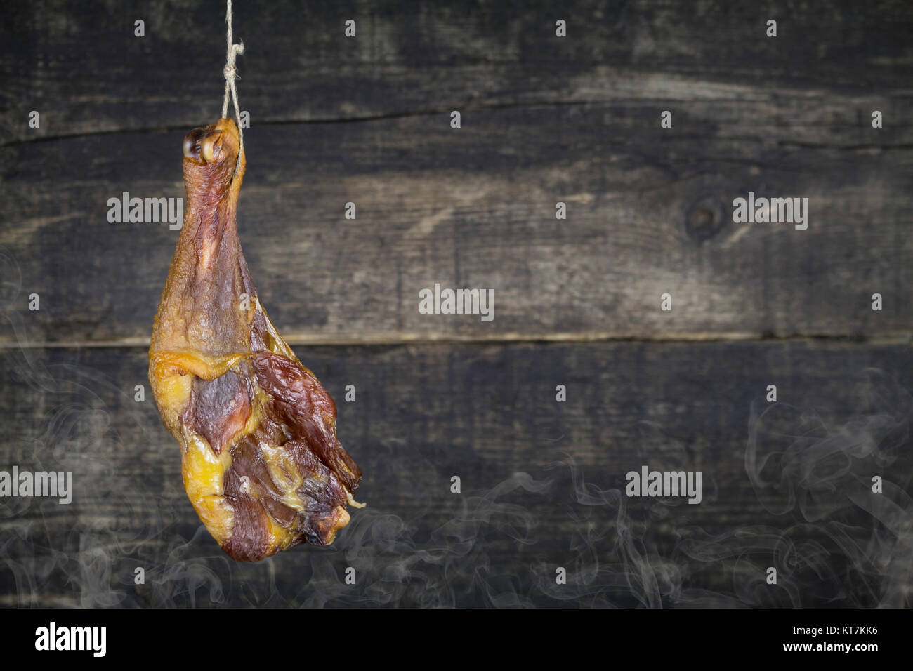 Smoked Chicken Leg Hanging on the Rope Against Wooden Background Stock ...