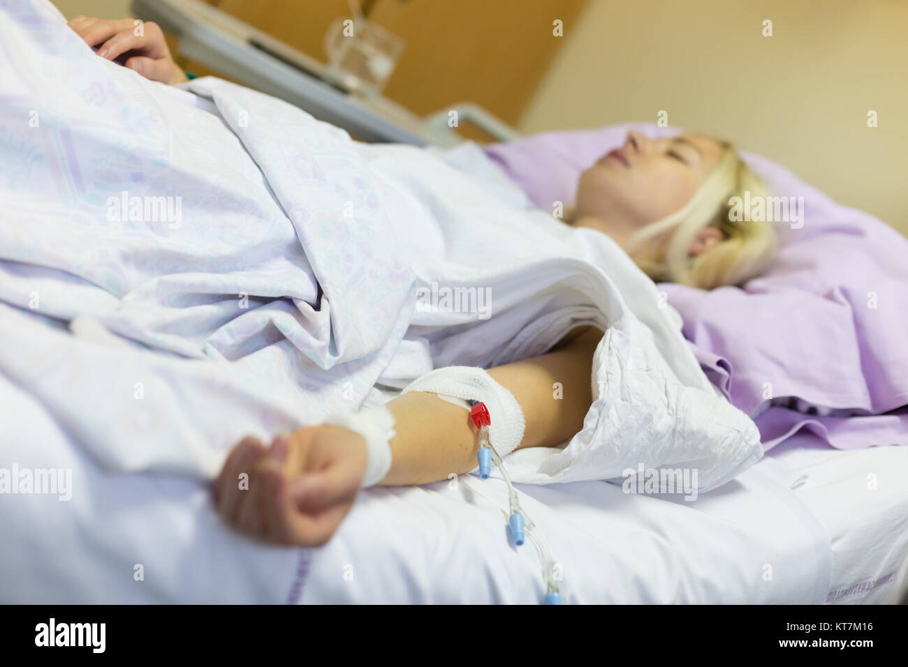 Bedridden female patient recovering after surgery in hospital care