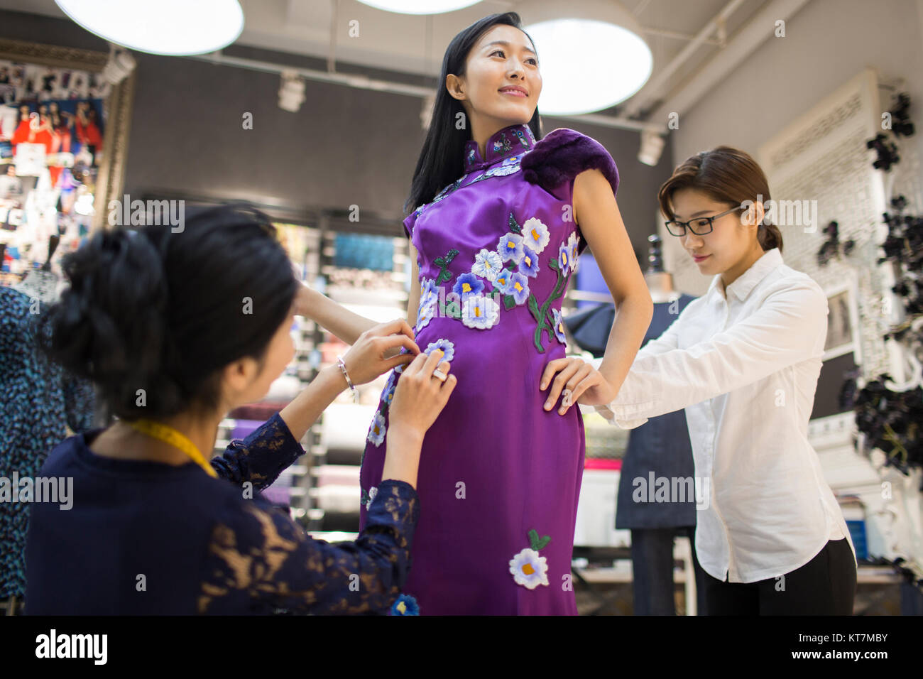 Fashion designers adjusting customer's dress Stock Photo