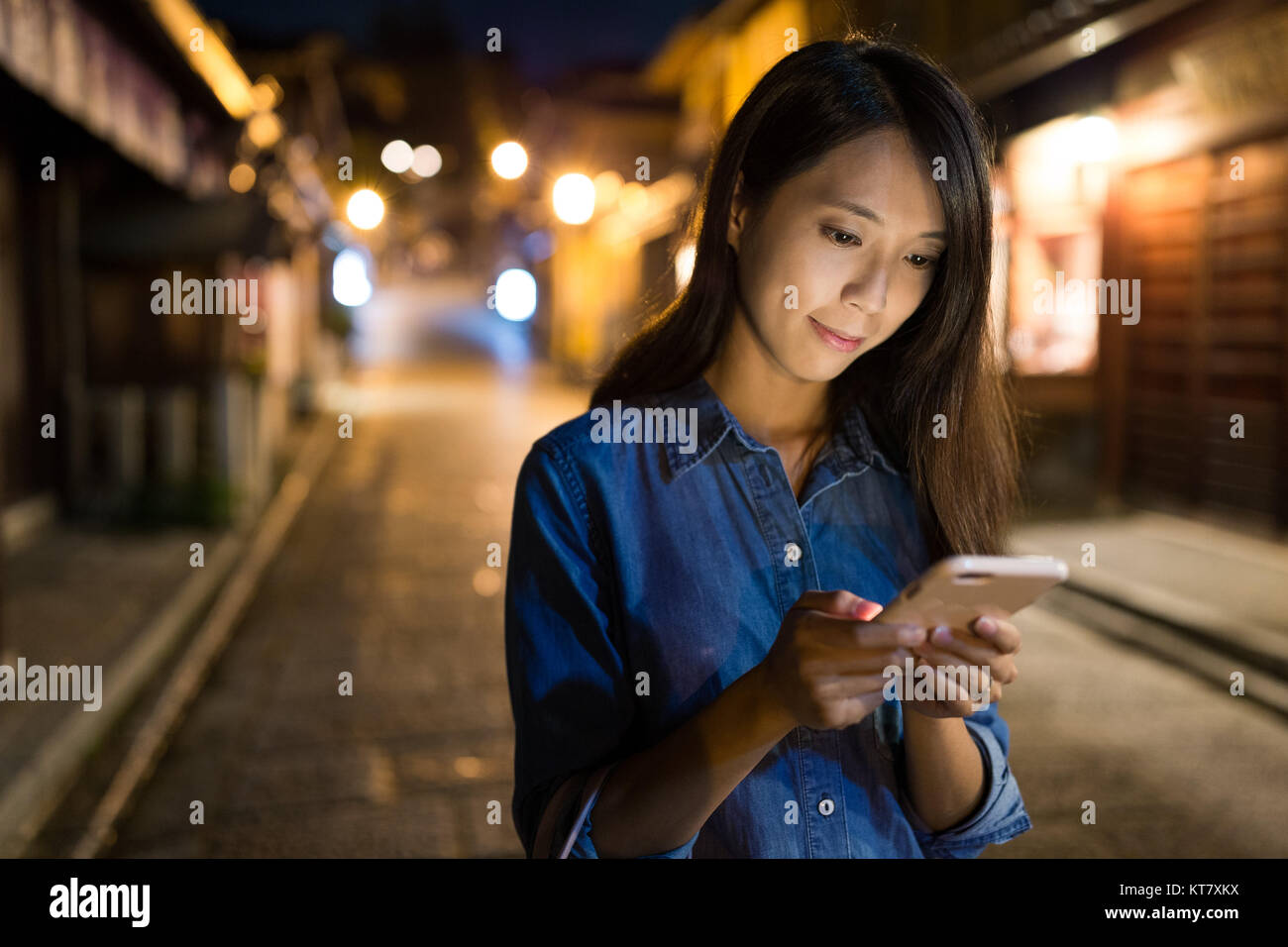 Woman looking at mobile phone at night Stock Photo - Alamy