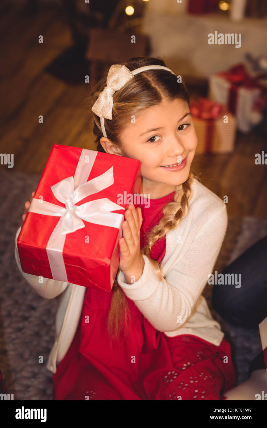 Girl holding christmas present Stock Photo - Alamy