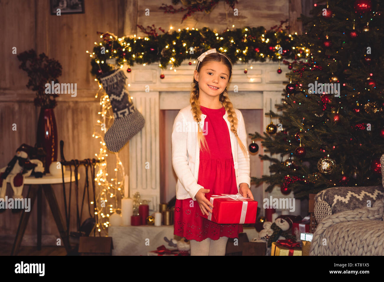 Girl holding christmas present Stock Photo - Alamy