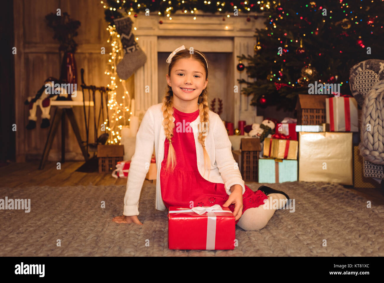 Girl holding christmas present Stock Photo - Alamy