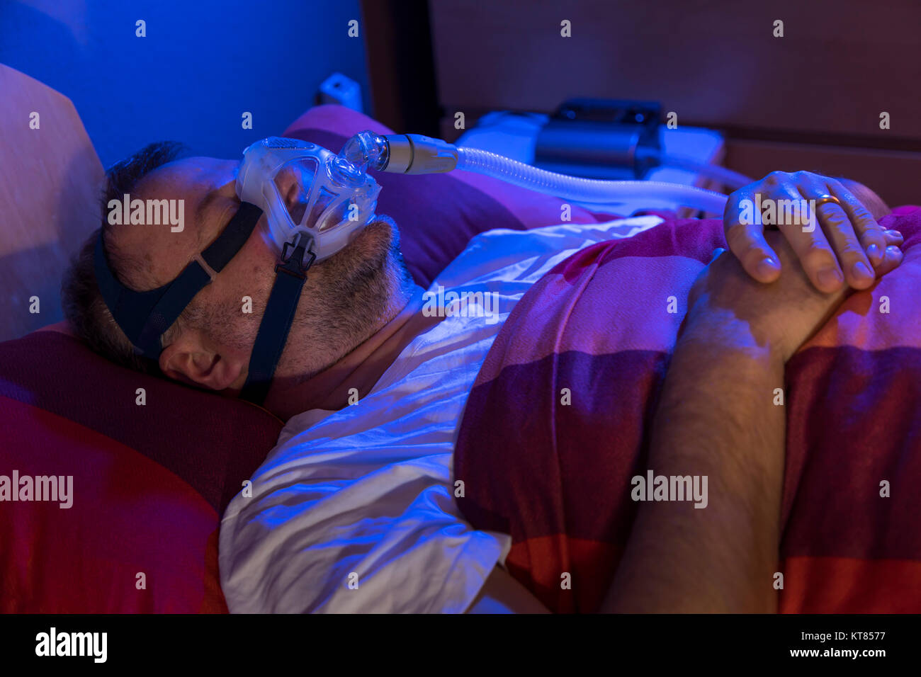 A man with sleep apnea syndrome, wears a CPAP mask while sleeping, breathing mask that presses