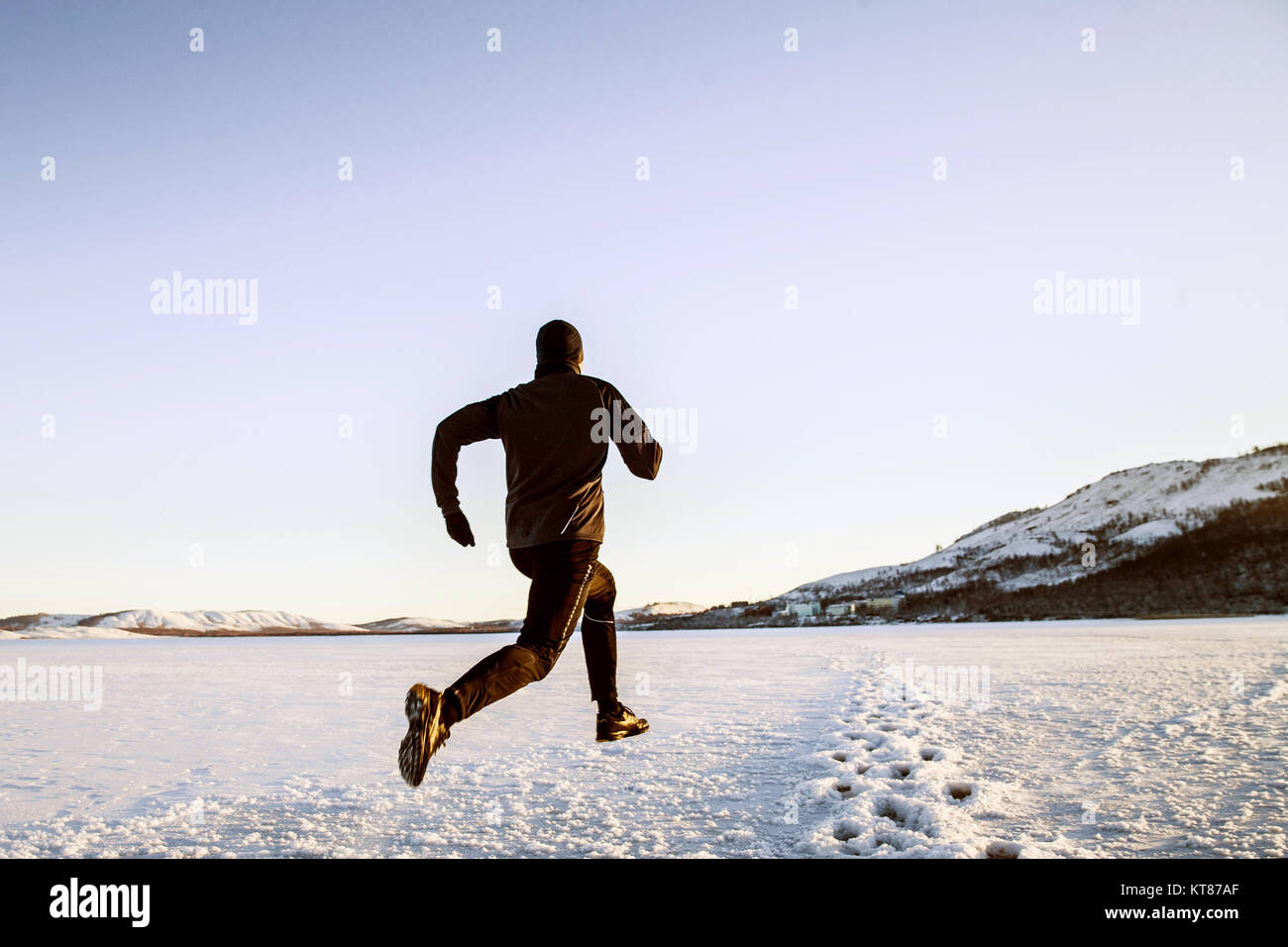 winter running in snow male runner athlete Stock Photo