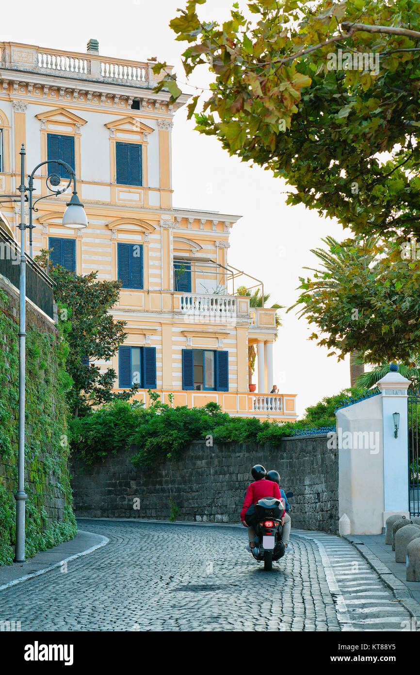 Tourists on motorcycle in the street at historical part of Sorrento, Amalfi coast, Italy Stock Photo