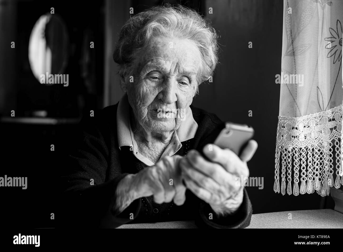 Elderly woman typing on the smartphone. Stock Photo