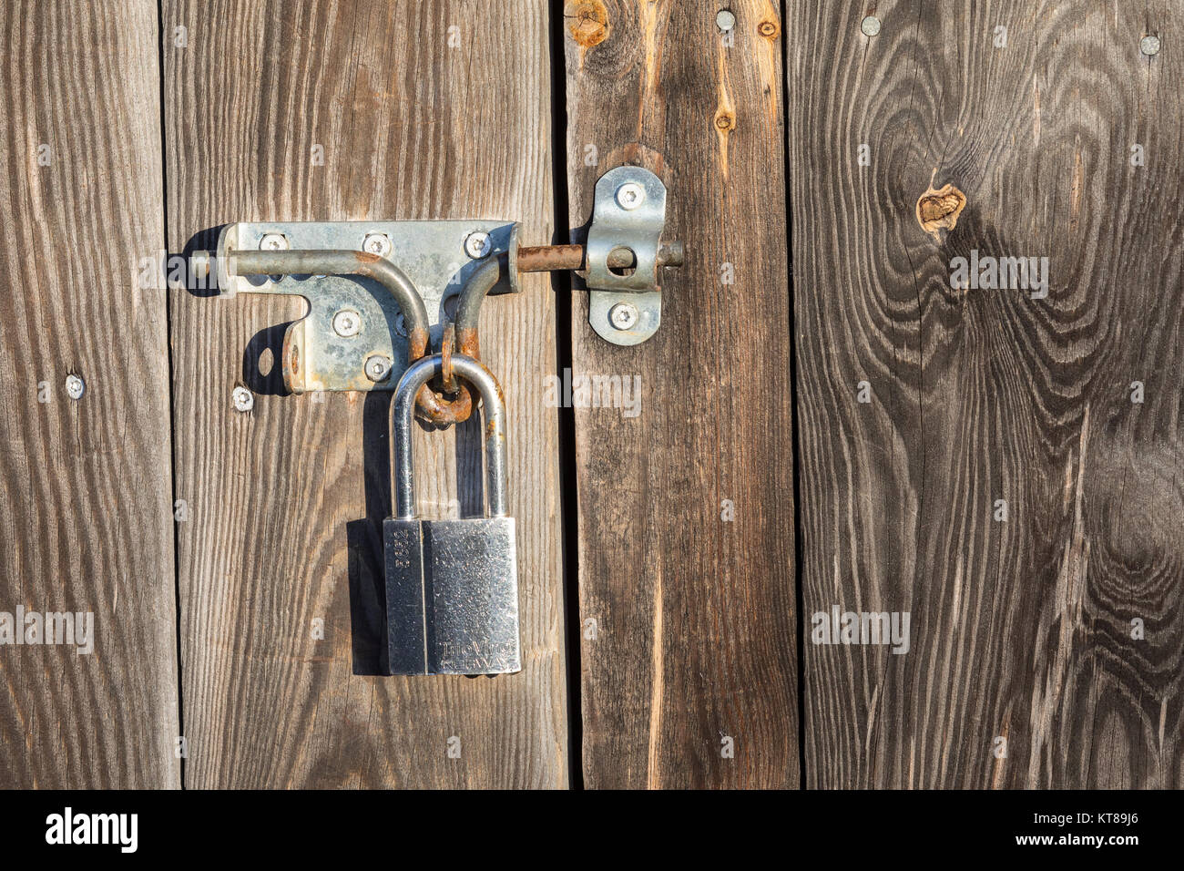 Metal lock on a wooden door, rusty and weathered Stock Photo - Alamy
