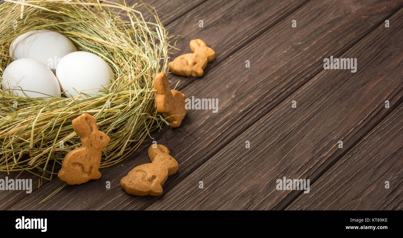 Easter eggs in a straw nest and cookies Stock Photo - Alamy