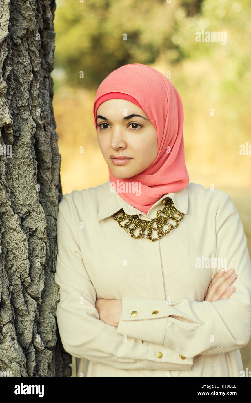 Beautiful Muslim woman leaning against a tree arms folded Stock Photo ...