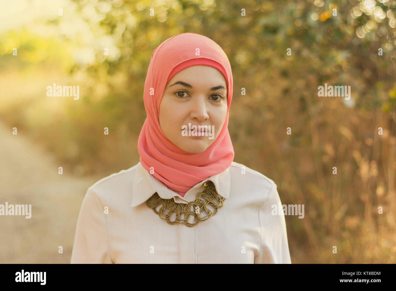 Beautiful Muslim woman standing outdoors Stock Photo